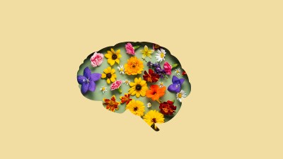 Paper cut brain symbol and flowers on yellow background